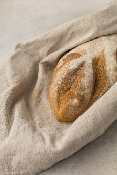 istock Gluten free fresh bread in kitchen towel on light background 1418200711