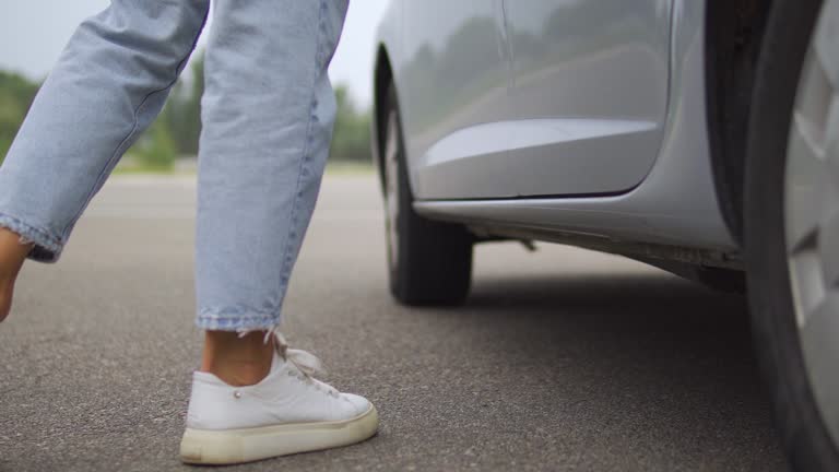 Woman opening door and getting out from car on parking lot, in hurry to work