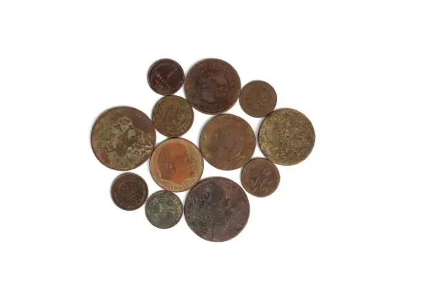 Photo of Antique round dirty coins lie on a white background.