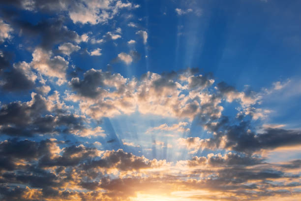 istock Beautiful rays of light and clouds. Divine sky, glow and shadows from dark clouds sunrise dusk. 1418210654