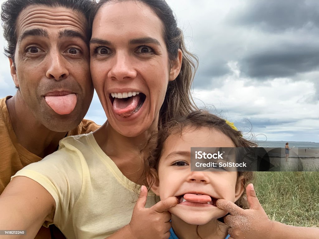 Lets Pull A Funny Face A close up selfie of three family members pulling faces and looking into the camera for a silly selfie on their trip to the beach in Seahouses in the North east of England Real Life Stock Photo