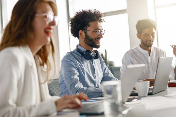 istock Group of young diverse coworkers analyzing sales report while working together in the office 1418215630