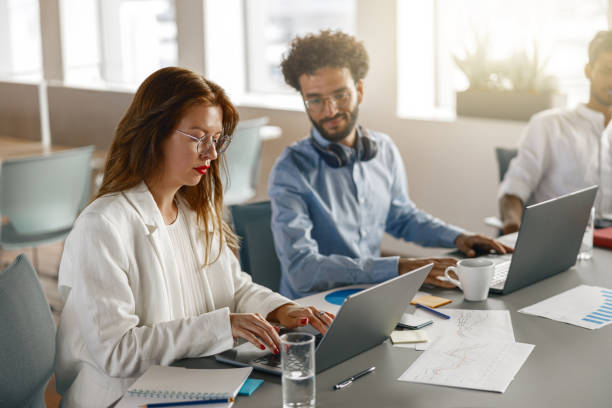 istock Group of young diverse coworkers analyzing sales report while working together in the office 1418215769