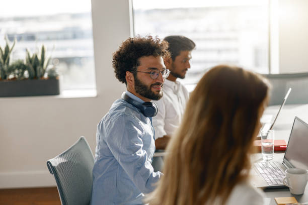 istock Group of smiling coworkers working together analyzing the charts in modern office 1418215830