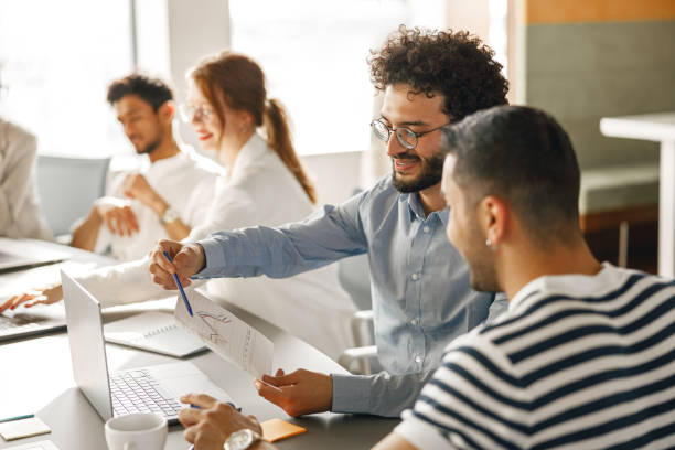 istock Diverse group of colleagues enjoying working together in an office. Teamwork concept 1418217574