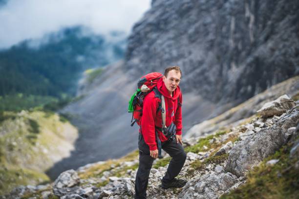 istock Caucasian climber in a red coat going up the hill 1418224255