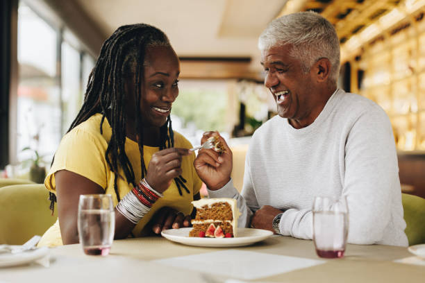 istock Senior couple eating a cake together in a cafe 1418226549