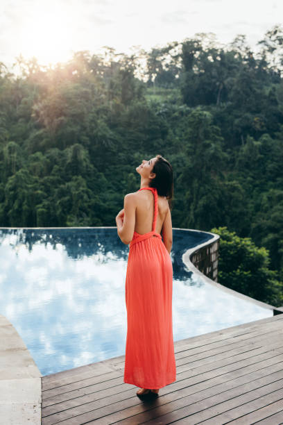 istock Young female model standing on the edge of pool 1418226754