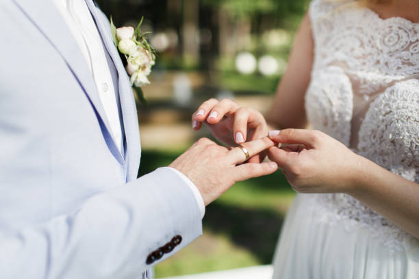 istock Bride and groom exchange rings at the wedding ceremony 1418228119