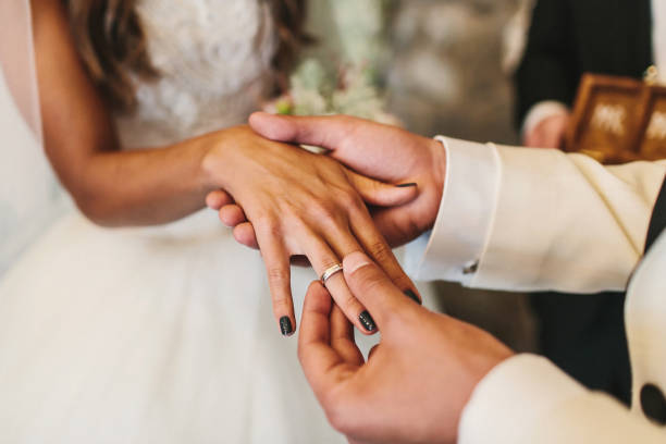 istock Bride and groom exchange rings at the wedding ceremony 1418228230