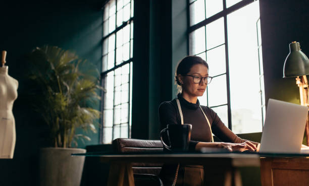 istock Fashion designer using laptop at her office desk 1418228757