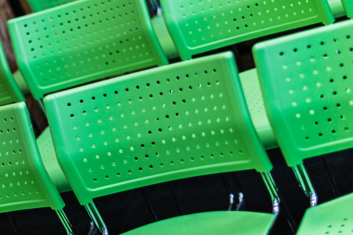 Close up image of bright green seats in a classroom, shallow focus at a tilted angle