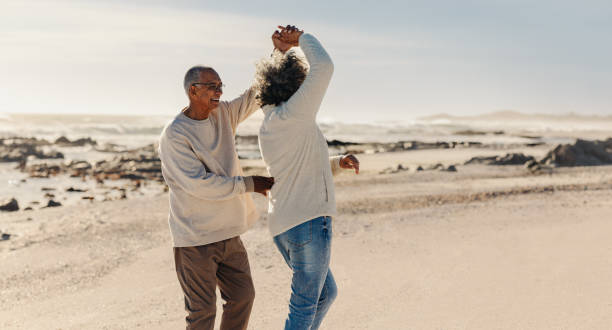 istock Elderly couple dancing at the beach 1418229787