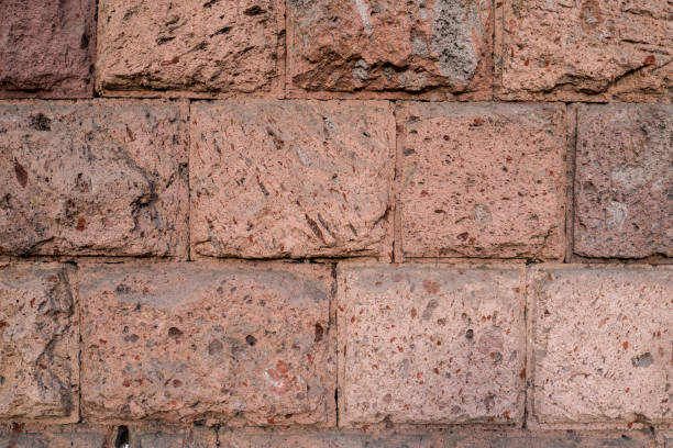 istock Wall texture with rough cut Quarry-faced masonry ashlar in red and brown 1418232726