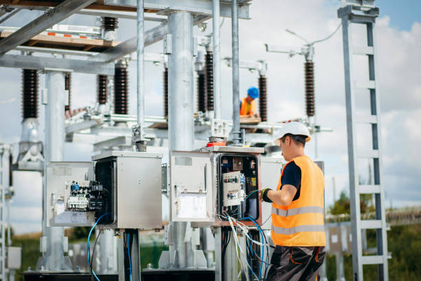 engenheiro elétrico adulto monta os sistemas elétricos no armário de controle do equipamento. instalação de estação elétrica moderna - subestação elétrica - fotografias e filmes do acervo