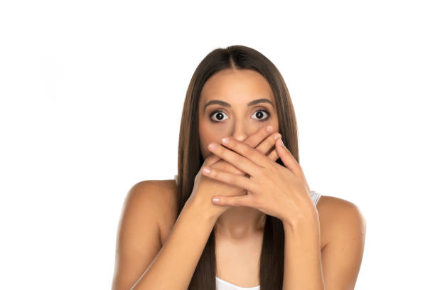 istock Shocked young woman covers her mouth with her hands 1418234182