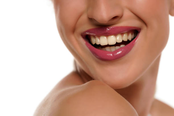 Smile, close up shot of a beautiful female mouth and lovely shiny white teeth smiling happily.