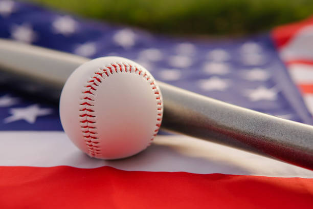 biała skórzana piłka i kij bejsbolowy leżące na fladze stanów zjednoczonych ameryki usa o zachodzie słońca. - baseball baseball bat baseballs patriotism zdjęcia i obrazy z banku zdjęć