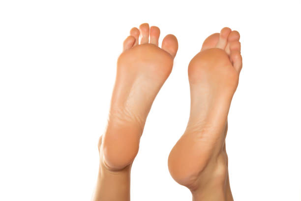 istock Beautiful woman's bare feet against a white background 1418237341