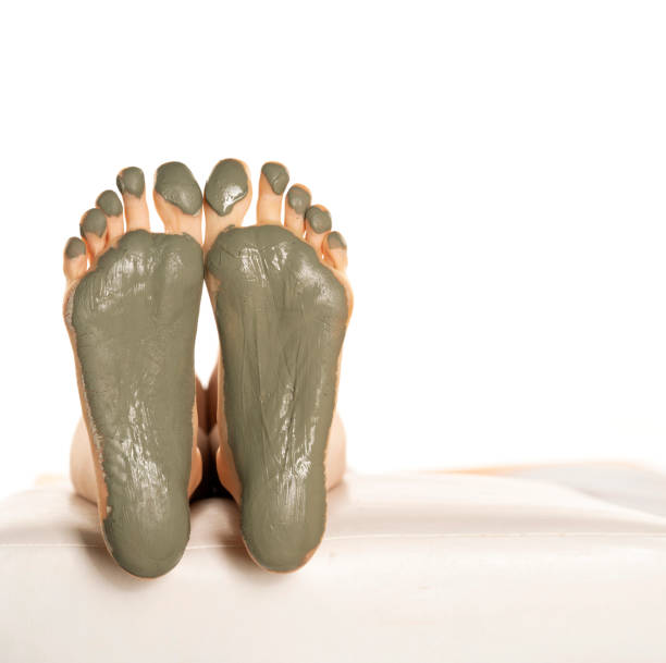 istock female feet with green mud mask on a white 1418238122