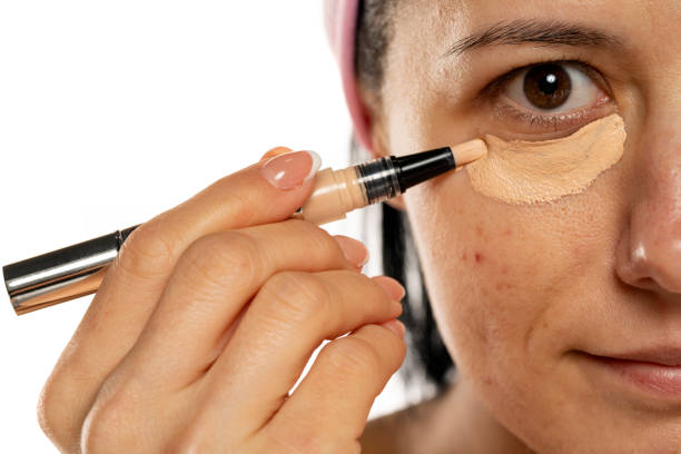 istock Middle aged woman apply concealer under the eye 1418240488