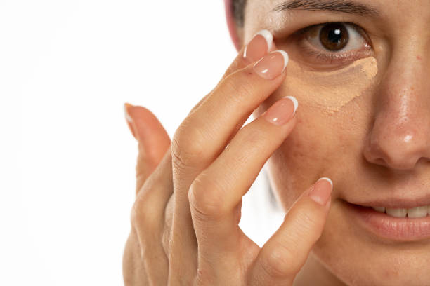 istock Middle aged woman apply concealer under the eye 1418240491
