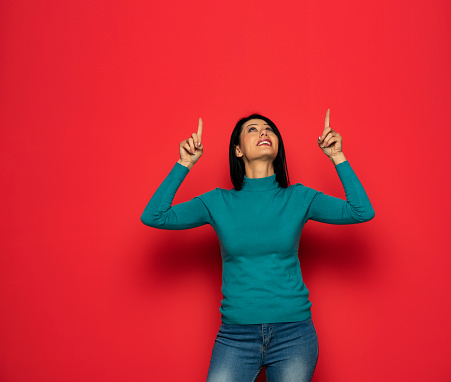 Young woman over isolated red background pointing with the index fingers a great idea