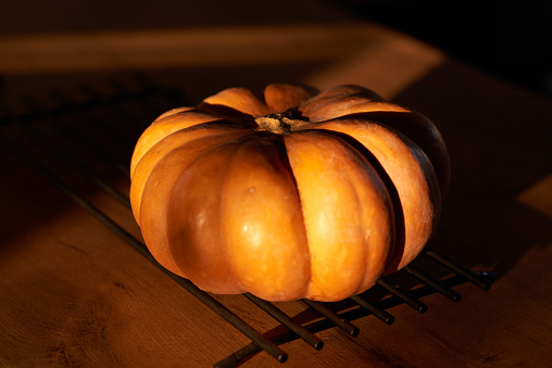 A still life of a pumpkin in the sunlight on the table. High quality photo