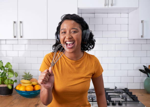 istock A young multi-ethnic woman sings into a whisk in a modern kitchen 1418240820