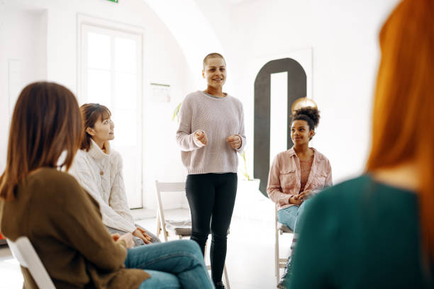 istock Smiling and cheerful coach talking about cancer to the group 1418245364