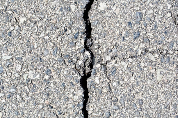 istock Cracked, broken and damaged asphalt road detail 1418246724
