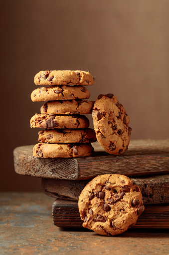 Freshly baked chocolate cookies on a rustic brown background. Copy space.