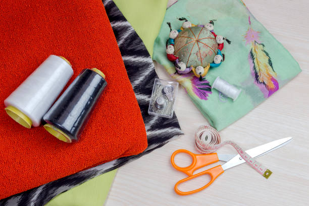 istock Fabric, scissors and various sewing supplies on a wooden table 1418256887