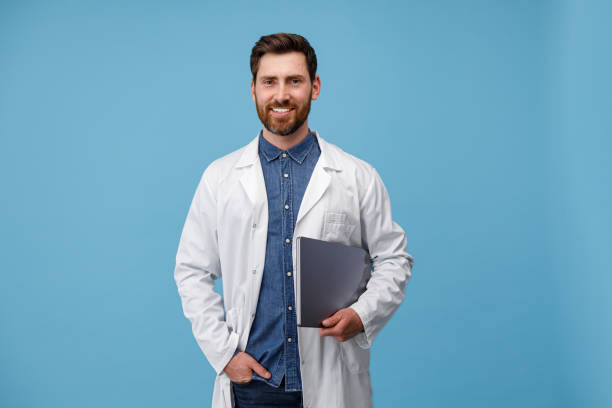 Professional Doctor In white uniform posing on camera with clipboard stock photo