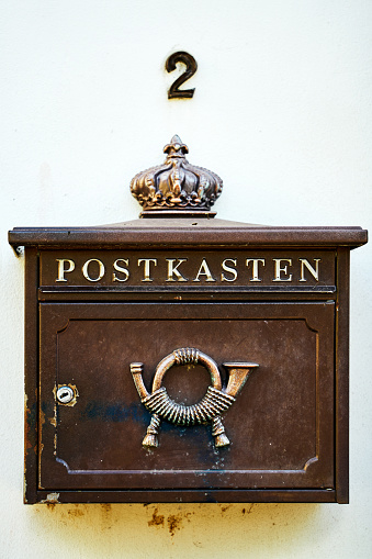 Private old-fashioned mailbox hanging on wall in the historic inner city of Merseburg, Germany