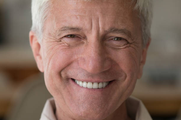 istock Older man with wide toothy smile staring at camera, closeup 1418260581