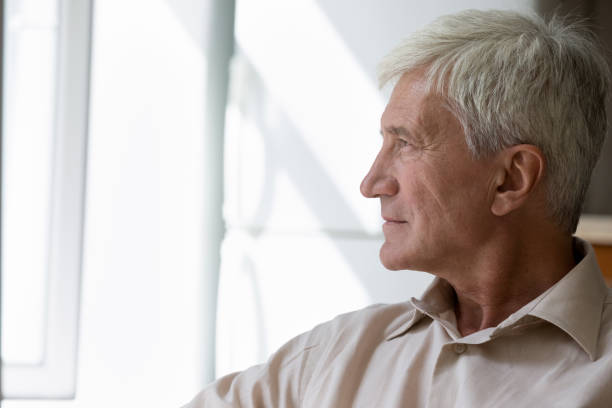 istock Side profile view pensive older man sit staring out window 1418260582