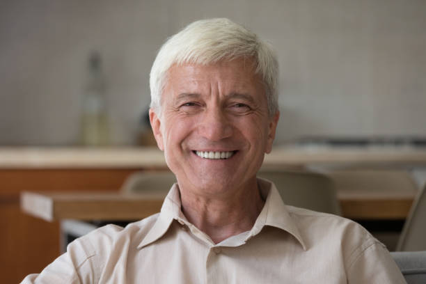 istock Headshot portrait handsome optimistic senior man posing on camera 1418260588