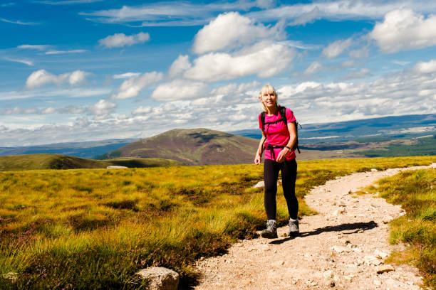 Hiking in the Cairngorms, Scotland Woman hiking the trail to a mountain called Bynack More, beside Strath Nethy, in the Cairngorms National Park, Scotland. cairngorm mountains stock pictures, royalty-free photos & images