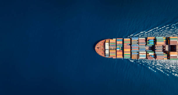 Aerial top down view of a large container cargo ship with copy space Aerial top down view of a large container cargo ship in motion over open ocean with copy space delivered stock pictures, royalty-free photos & images