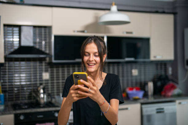 istock Happy Young Woman using Smart Phone at Home 1418267711