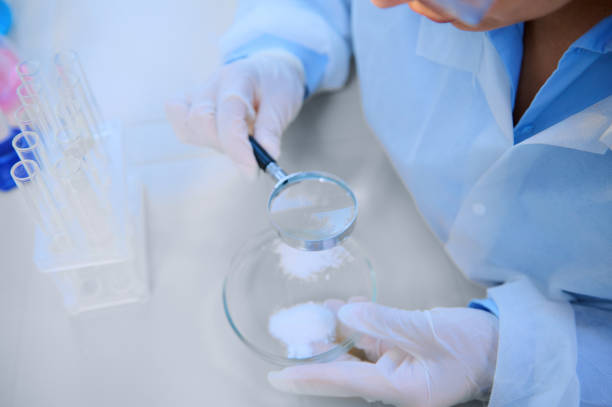 istock Top view of scientist using loupe with magnifying glass to study pharmacological substance on petri dish in laboratory 1418271625
