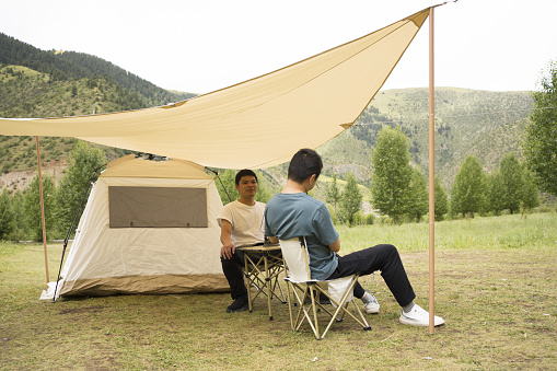 Asian men go camping outdoors and have a pleasant exchange