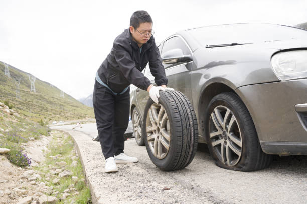 istock A man is changing a car tire 1418272349