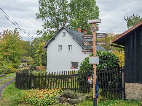 Tourist guide post at small village Travnik, autumn trees and countra houses. Luzicke hory, Lusatian Mountains.
