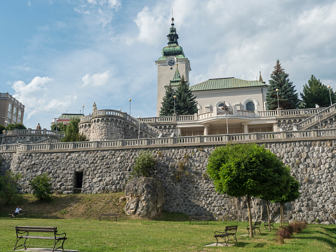Ruzomberok, Slovakia, August 30, 2020: View of park in Ruzomberok old town city center with baroque church St. Andrew, historical building Farsky kostol sv. Ondreja, northern Slovakia, Liptov region.