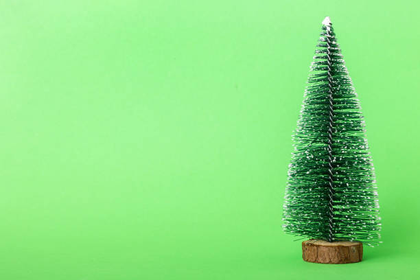 istock One small Christmas tree on colored background. new year decoration with copy space 1418278262