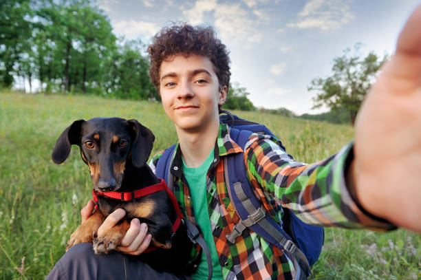 chłopiec ze swoim psem robiąc selfie na spacerze - teenagers only lake summer sunlight zdjęcia i obrazy z banku zdjęć