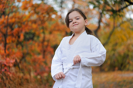 Little girl holding in hands her karate belt