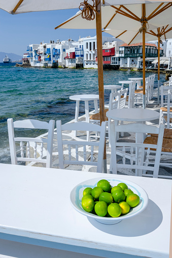 A plate of green limes on the table of outdoor restaurant in Mykonos, Greece